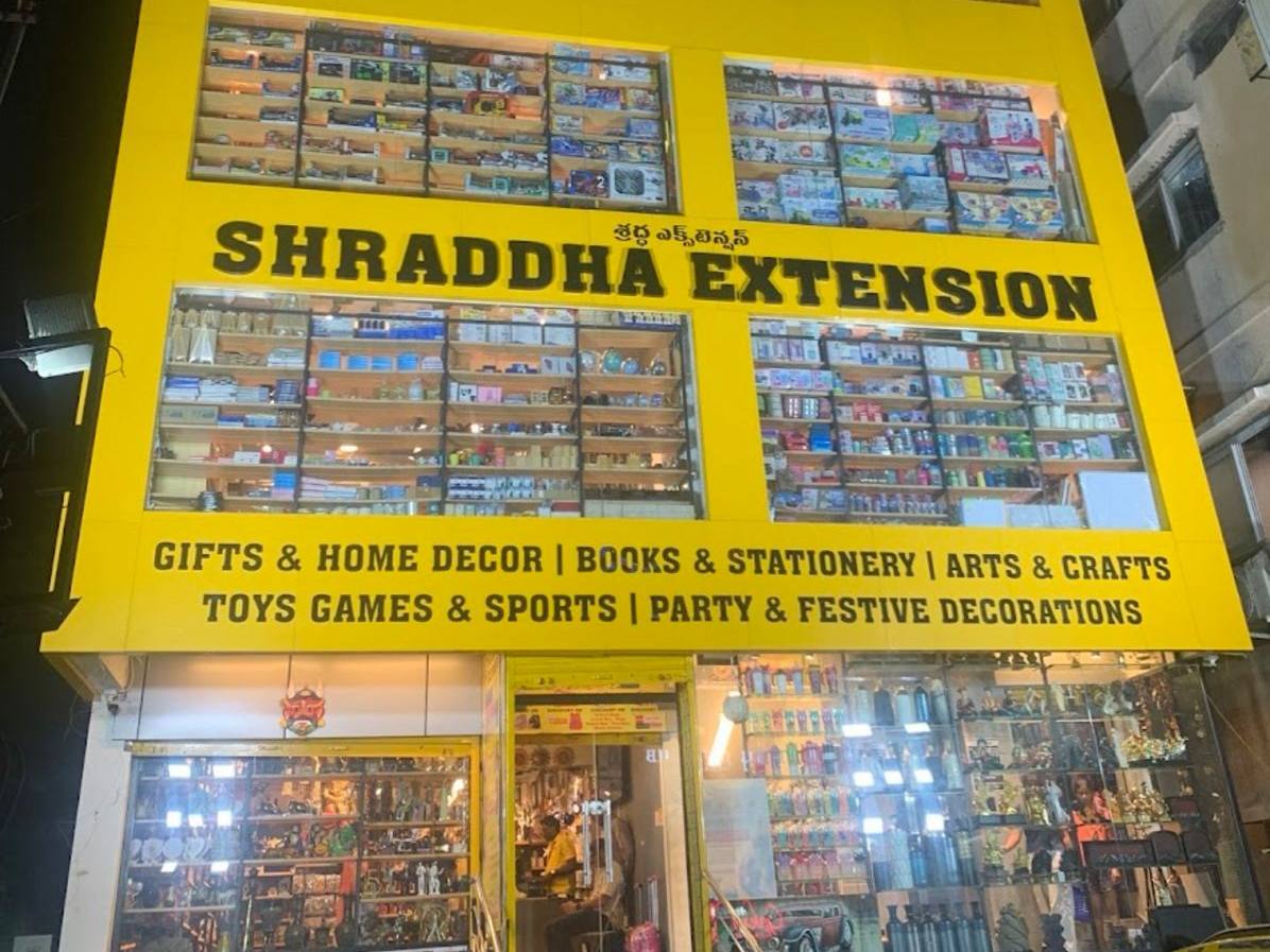 Shraddha Extension Nalagandla store front at night, a yellow multi-storey building with lit display windows